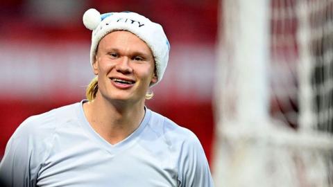 Erling Haaland smiling while in a Christmas hat