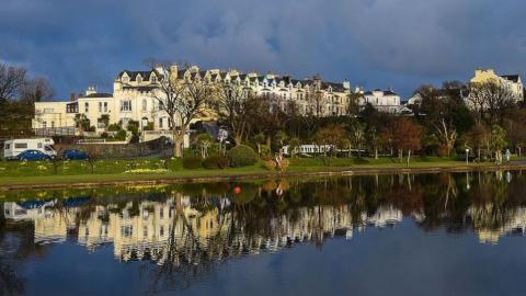 Buildings opposite the Mooragh Park with their reflections captured on the surface of the boating lake.