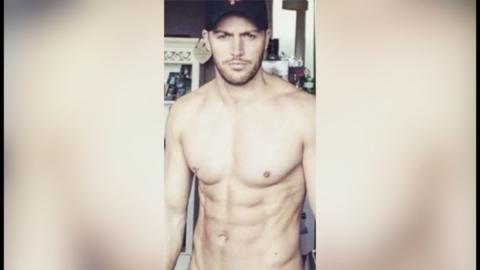 A shirtless man looks at the camera