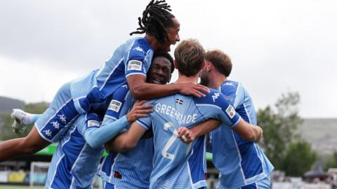 Tom Harrison is mobbed by his Truro team-mates after his last-ditch equaliser