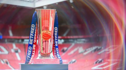 The Super League trophy on a pedestal at Old Trafford