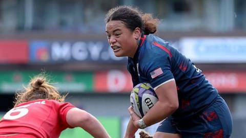 Freda Tafuna powers through two Wales tackles.
