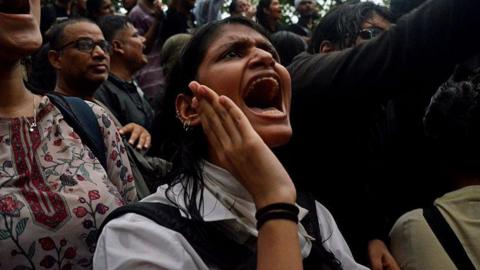 A crowd gathered at Delhi's Jantar Mantar in solidarity with the Cockroach Janata Party, demanding educational reforms and India's education minister Dharmendra Pradhan's resignation on 22 July. A woman protester wearing a white shirt participates in sloganeering.