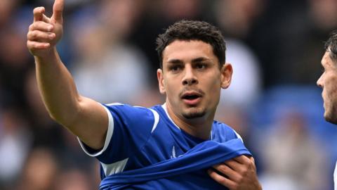 Yousef Salech lifts his arm in the air while playing against Bolton