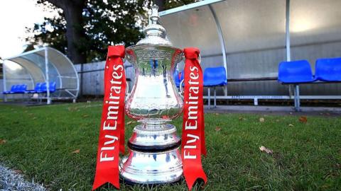General view of the FA Cup trophy on display on the sideline at a qualifying round match in 2016