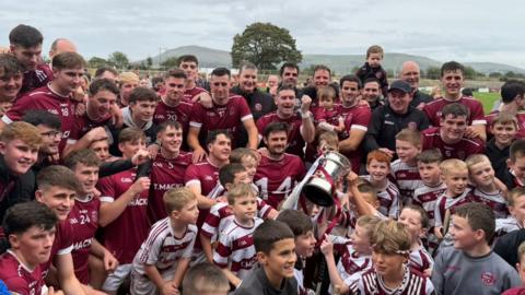 The Slaughtneil players celebrate winning the Derry title with their fans
