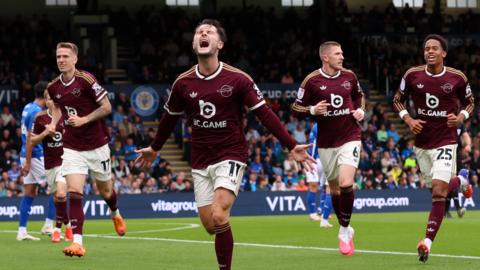 Liam Cullen runs with his arms held out wide behind him in celebration of a goal, as three team-mates run behind him