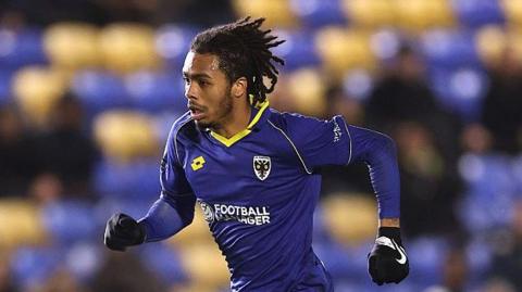 Antwoine Hackford runs with the ball while playing for AFC Wimbledon