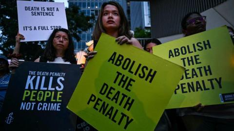 Activists in Kuala Lumpur hold placards during a vigil in February 2025 against the execution of a Malaysian national sentenced to death for drug trafficking into Singapore