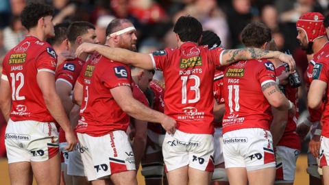 Scarlets players in a huddle in their derby against Ospreys