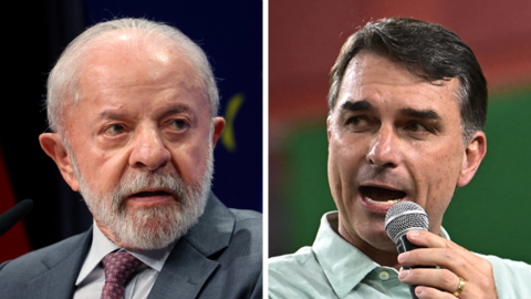 A composite image shows Luíz Inácio Lula da Silva, wearing a grey suit jacket and a burgundy tie, at the left, and Flávio Bolsonaro, wearing a light green shirt but no tie, speaking into a microphone.