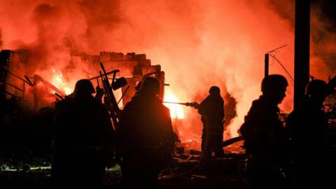 Firefighters work at the site of a car garages of residents which were hit by an overnight Russian missile strike, amid Russia's attack on Ukraine, in Zaporizhzhia, Ukraine.