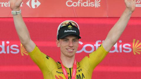 Team Visma-Lease a bike's British rider Matthew Brennan celebrates on the podium after winning the 17th stage of the Vuelta a Espana 2026