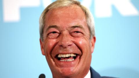 Nigel Farage grinning broadly against a turquoise background