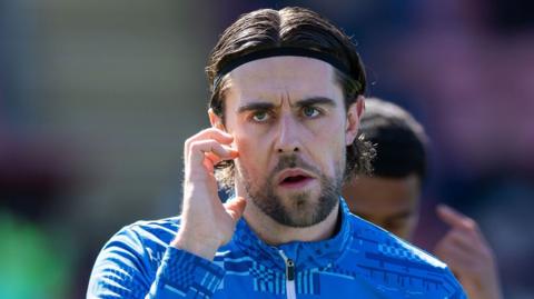 Huddersfield Town midfielder Antony Evans warms up prior to the League One match against Leyton Orient on 6 April 2026