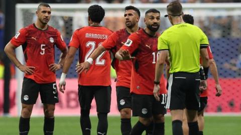 Egypt's players confront referee François Letexier during the 3-2 defeat to Argentina in the last-16 at the World Cup