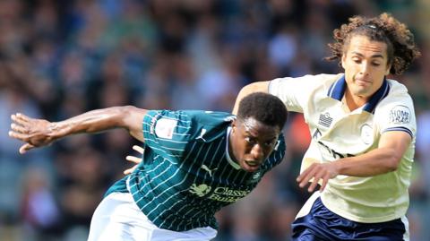 Wes Harding of Plymouth Argyle battles for the ball with Charlie Webster of Burton Albion