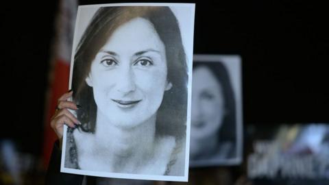Protesters hold a black and white picture of the late journalist Daphne Caruana Galizia