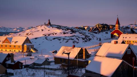 Sun setting on a snow-covered part of Nuuk in Greenland