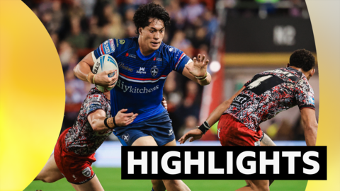 Isaiah Vagana of Wakefield runs as he is tackled around the waist by a Leigh player