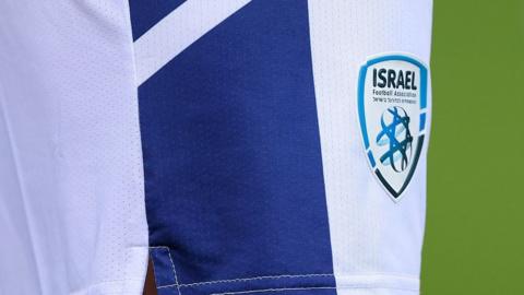A close-up shot of the badge of the Israel Football Association on the shorts of a national team player during an international fixture