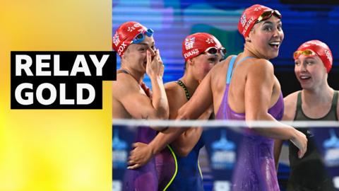 Great Britain's swimming relay team smiling immediately after winning gold