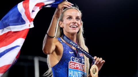 Georgia Hunter Bell celebrates victory in the 1500m at Birmingham 2026 by holding up her gold medal and union flag