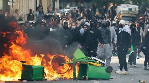 Bins and bicycles are set on fire on the streets of Paris