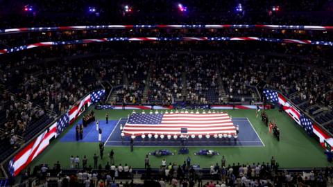 A giant flag is unfurled on the Arthur Ashe Stadium on the 25th anniversary of the 9/11 attacks