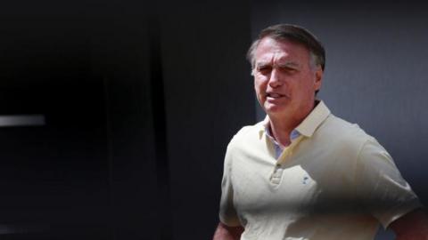 Brazil's former president Jair Bolsonaro walks at his residence in Brasilia, Brazil, 3 September 2025. He is wearing a pale yellow polo shirt. His brow is furrowed.
