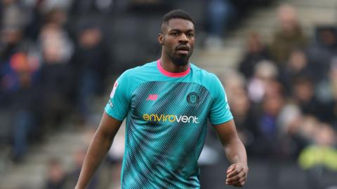 A photo of Emile Acquah, wearing a light blue Harrogate Town kit, during the side's game against MK Dons in March