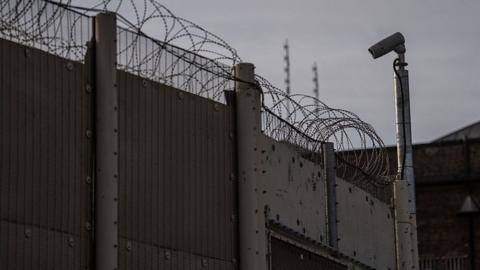 A barbed wire fence and CCTV camera outside HMP Wandsworth
