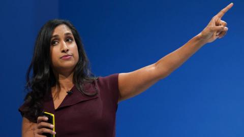 Shadow energy secretary Claire Coutinho pointing upwards, during a presentation about energy costs during a Conservative party conference speech