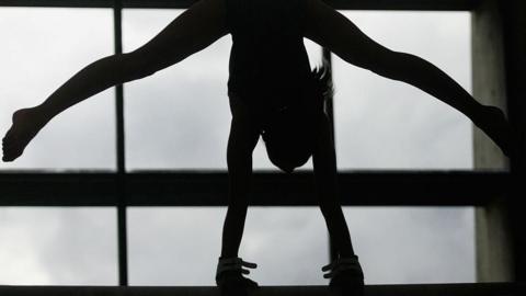 A stock picture of a gymnast in black and white.