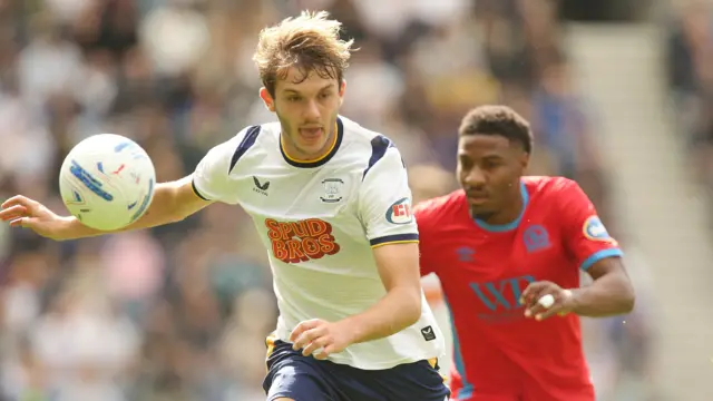 Preston North End's Stan Mills is chased down by a Blackburn Rovers player during their match on Saturday