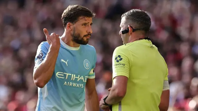 Ruben Dias of Manchester City appeals to referee Michael Oliver after Phil Foden is sent off