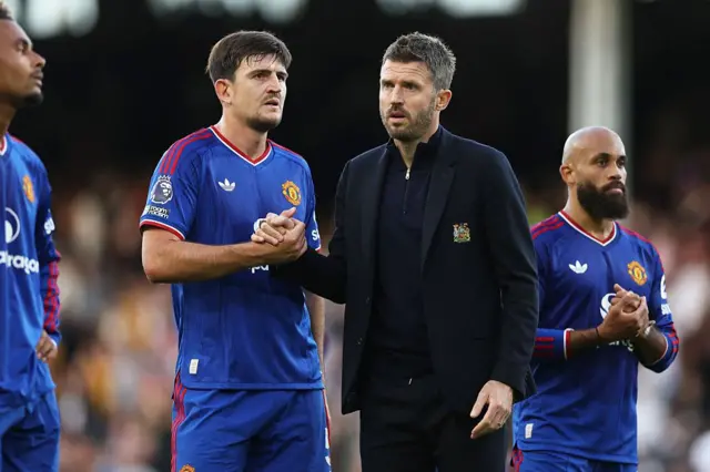 Harry Maguire of Manchester United shakes hands with Michael Carrick, manager of Manchester United,