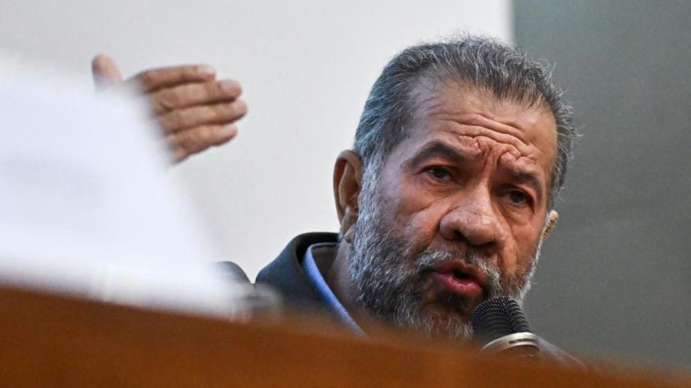 Carlos Lupi speaks into a microphone.