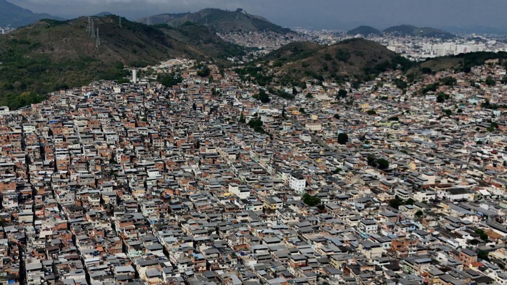 A drone view shows densely packed homes in the Penha favela complex, where the country's deadliest security operation in modern Brazilian history against drug trafficking was executed, in Rio de Janeiro, Brazil, November 4, 2025.
A warren of small houses can be made out against the backdrop of green hills.