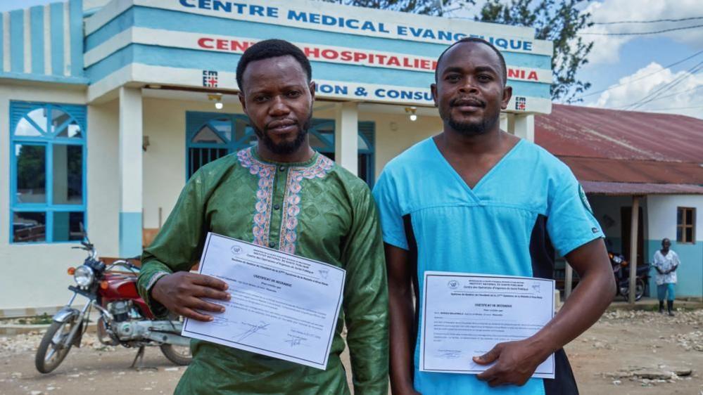 Makati Tagirabo,34, and Baraka Bulambula 29, Congolese health workers who recovered from the Ebola virus hold their certificates of discharge at the Evangelical Medical Center (CEM), as agencies intensify efforts to contain a new Ebola outbreak caused by the Bundibugyo virus strain, in Bunia, Ituri province, Democratic Republic of Congo, May 31, 2026. REUTERS/Gradel Muyisa Mumbere
