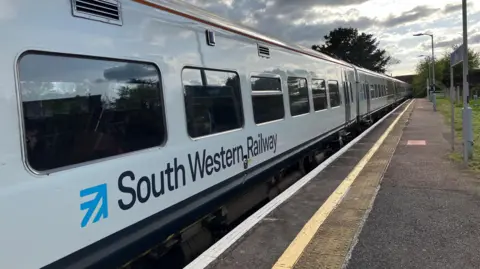 South Western Railway carriage pulls into train platform