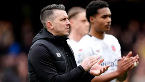 Luton Town manager Matt Bloomfield applauds the fans at the end of the match at Vicarage Road