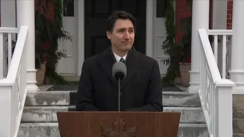 Justin Trudeau stands in front of a wooden podium.