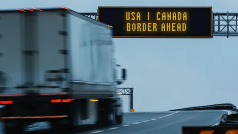 A semi-truck approaches the US-Canadian border