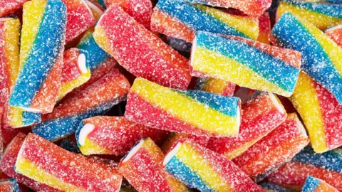 Rainbow sour jelly candy covered in sugar sprinkles