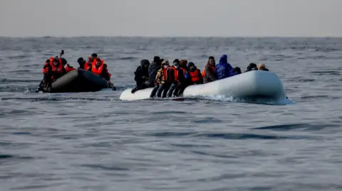 Two inflatable dinghies carrying migrants make their way towards England in the English Channel