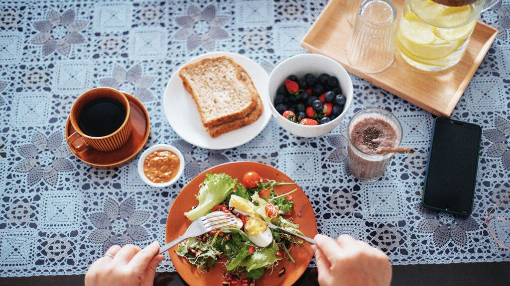 directly above an asian adult woman enjoying a healthy breakfast containing essential nutrients