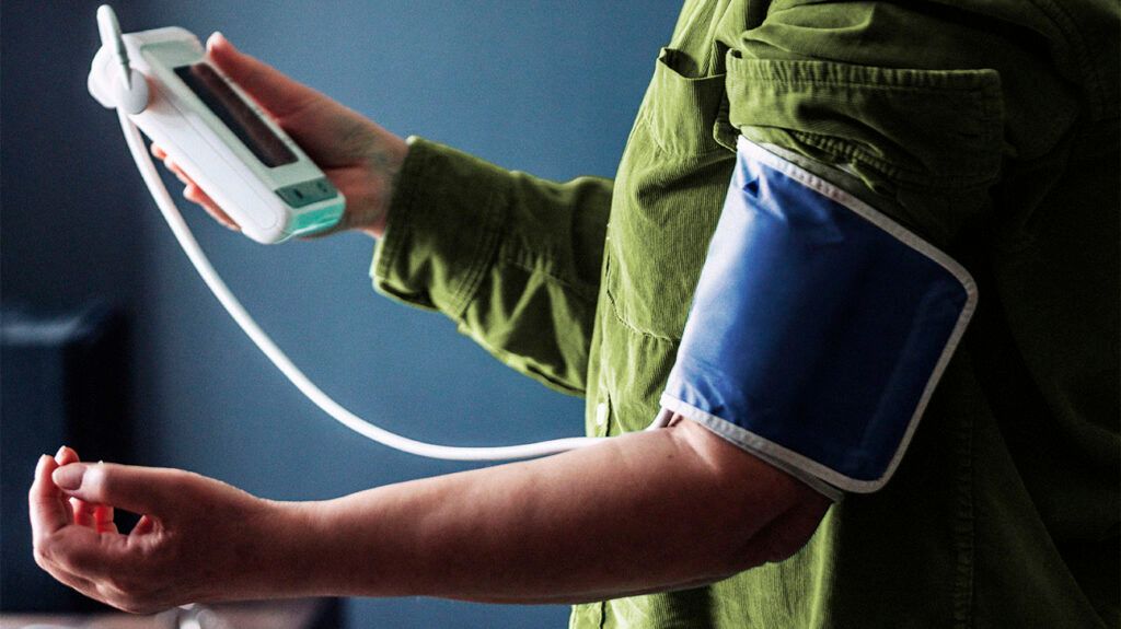 A person checking their blood pressure using a pressure cuff.