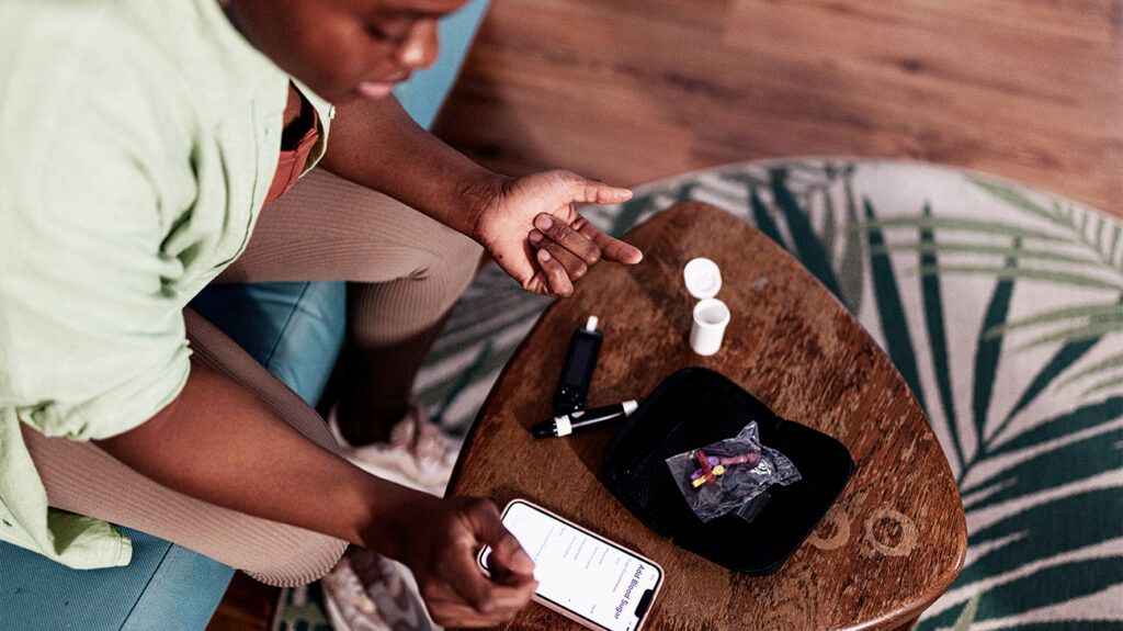 Diabetic woman checking glucose level at home