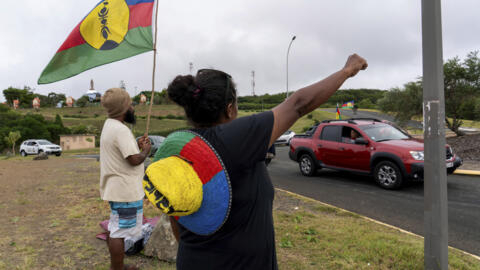 法国海外省新喀里多尼亚的一名妇女挥舞着卡纳克原住民和社会主义民族解放阵线 (FLNKS) 的旗帜   2024年5月15日首都努美阿 